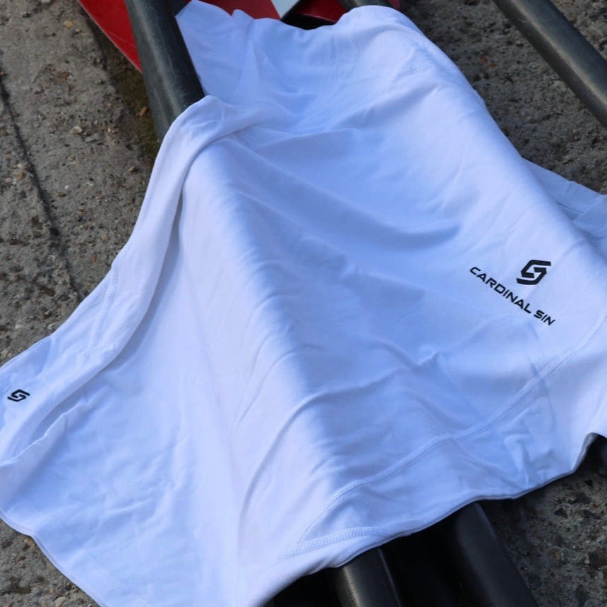 White t-shirt with a brand logo on a metal surface